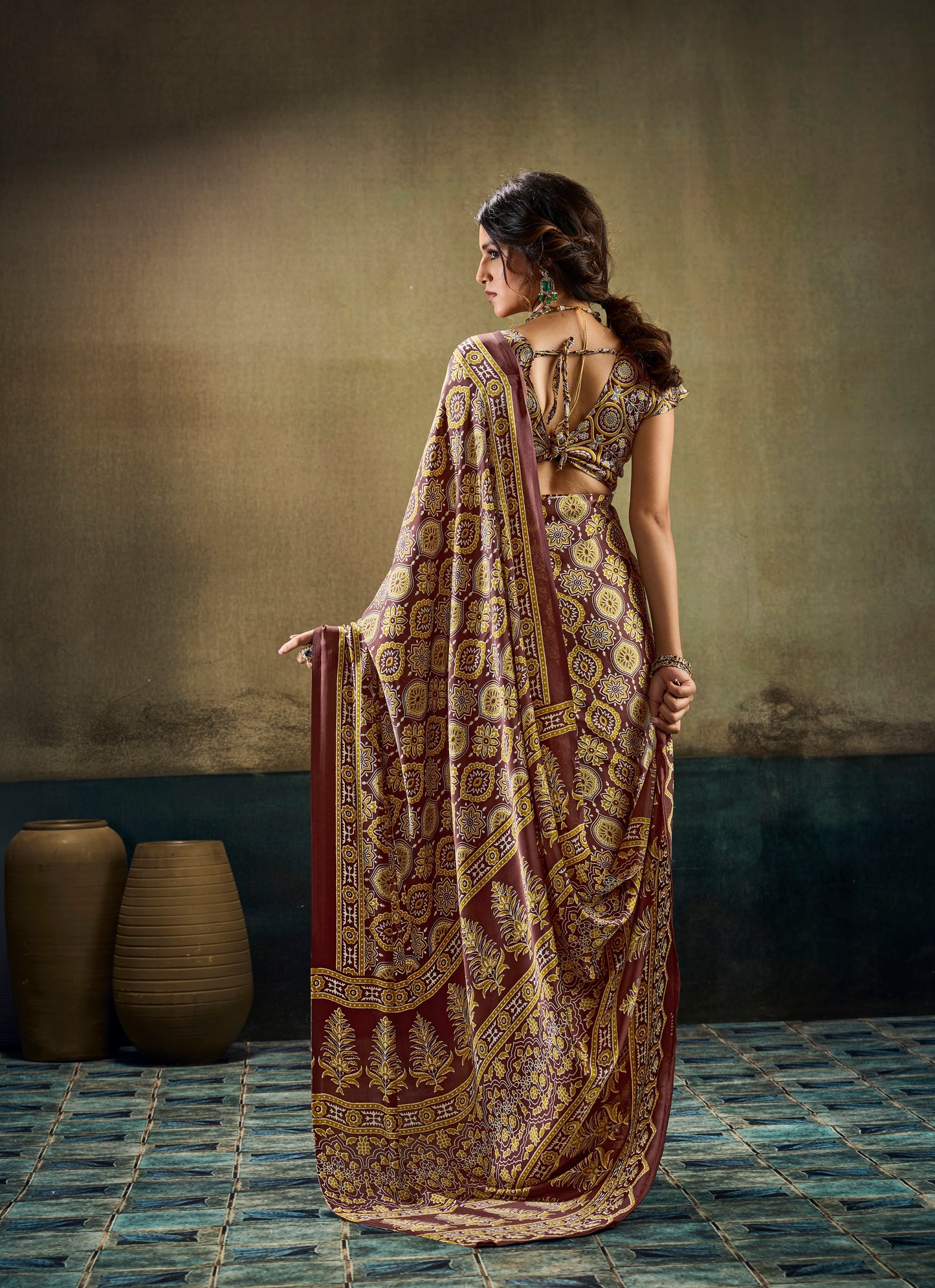 Brown patterned draped saree with short sleeves, detailed border and pallu fall