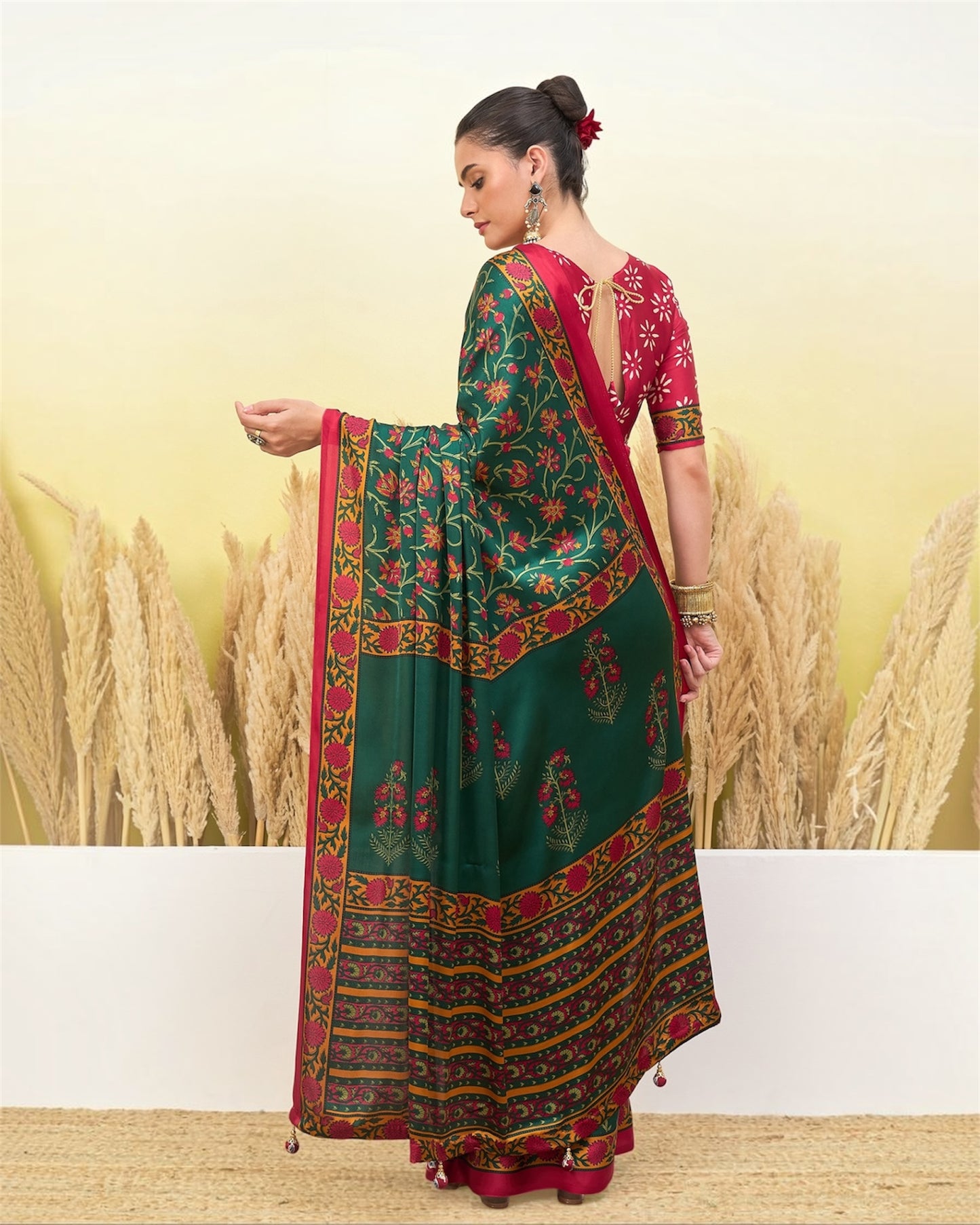 Green printed saree with maroon and gold border, draped with pleated pallu