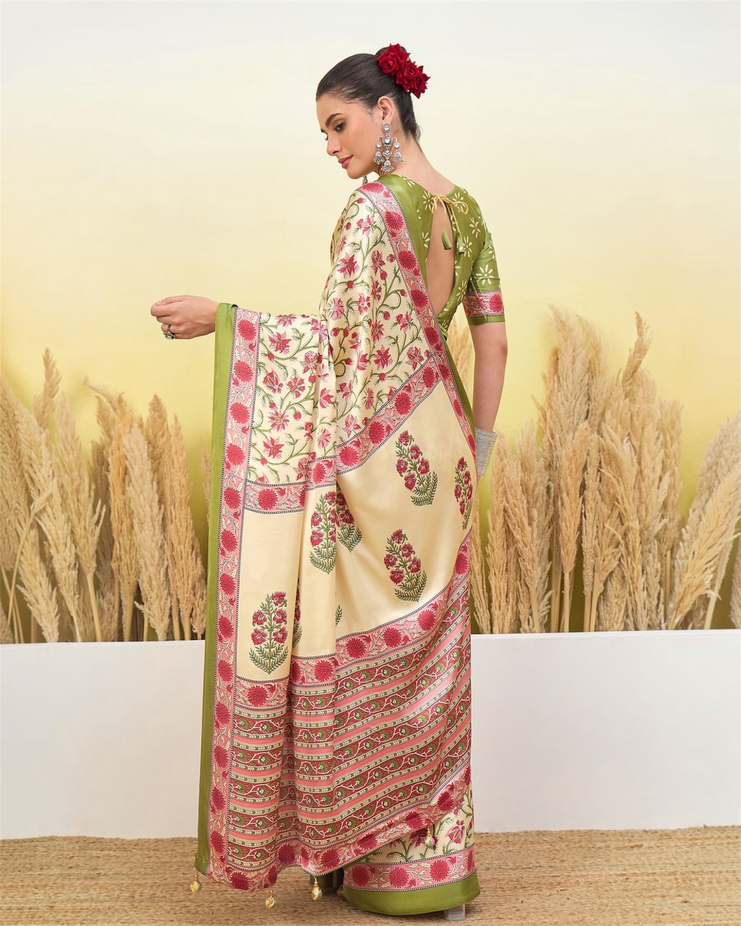 Ivory crepe silk saree with green border, red floral pallu, front drape view.