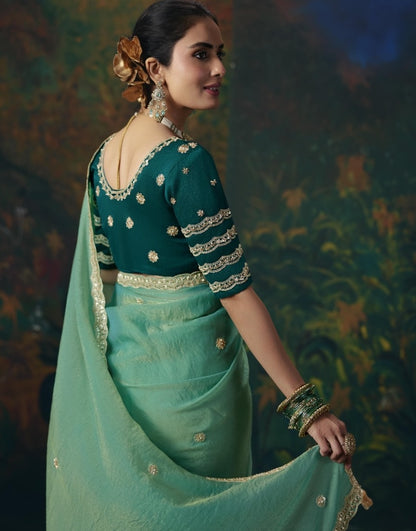 Back view of sea green silk saree with gold trim and dark teal embroidered blouse
