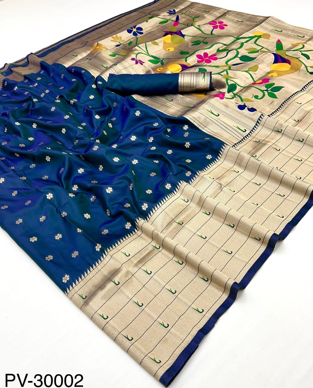 Laid-out blue and beige silk saree with gold motifs and colorful floral vine border