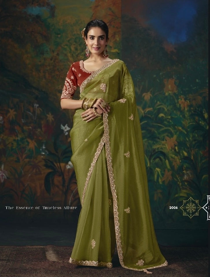 Olive green tissue silk saree with gold floral accents and ornate border, worn with a red blouse