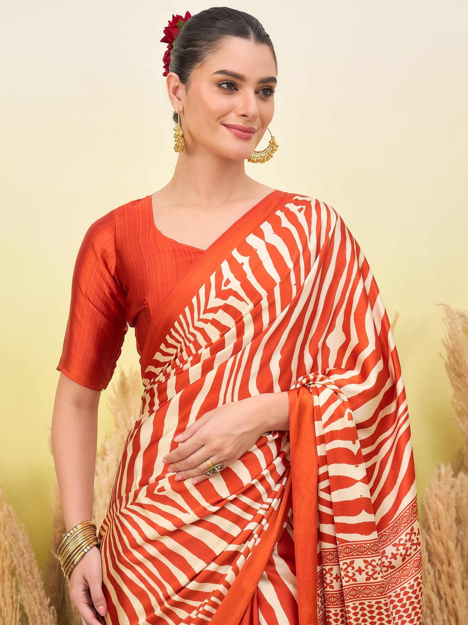 Orange striped crepe silk saree with gold border and short-sleeve blouse