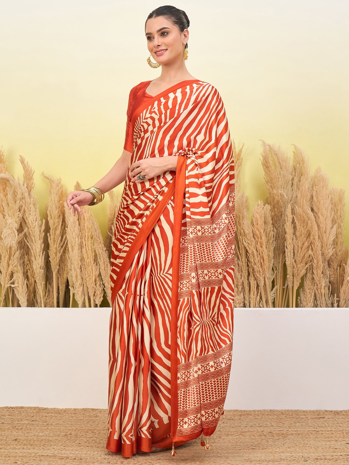 Orange striped crepe silk saree with gold border, pleated drape and pallu