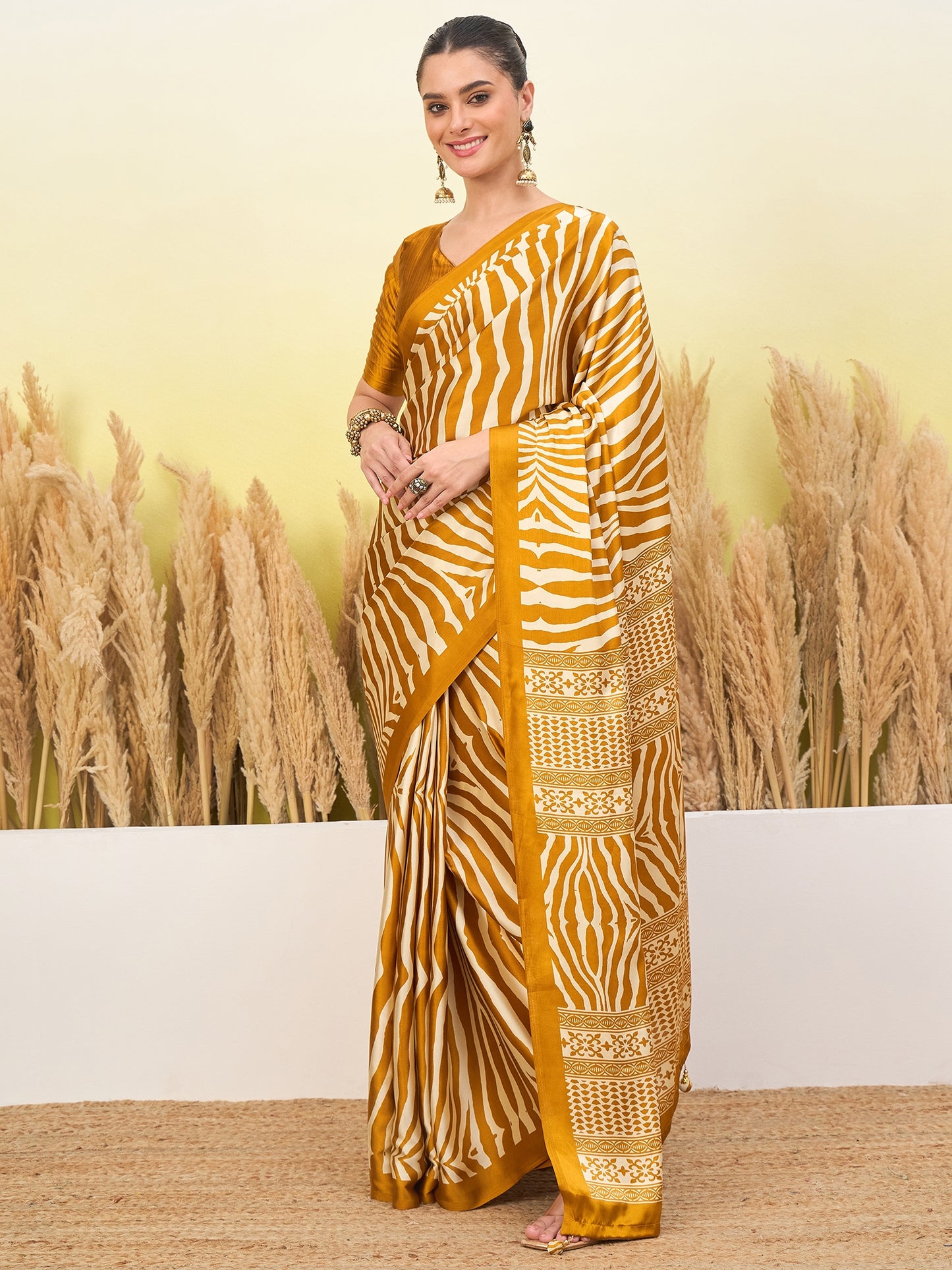 Mustard yellow striped saree with gold border and draped pallu over shoulder