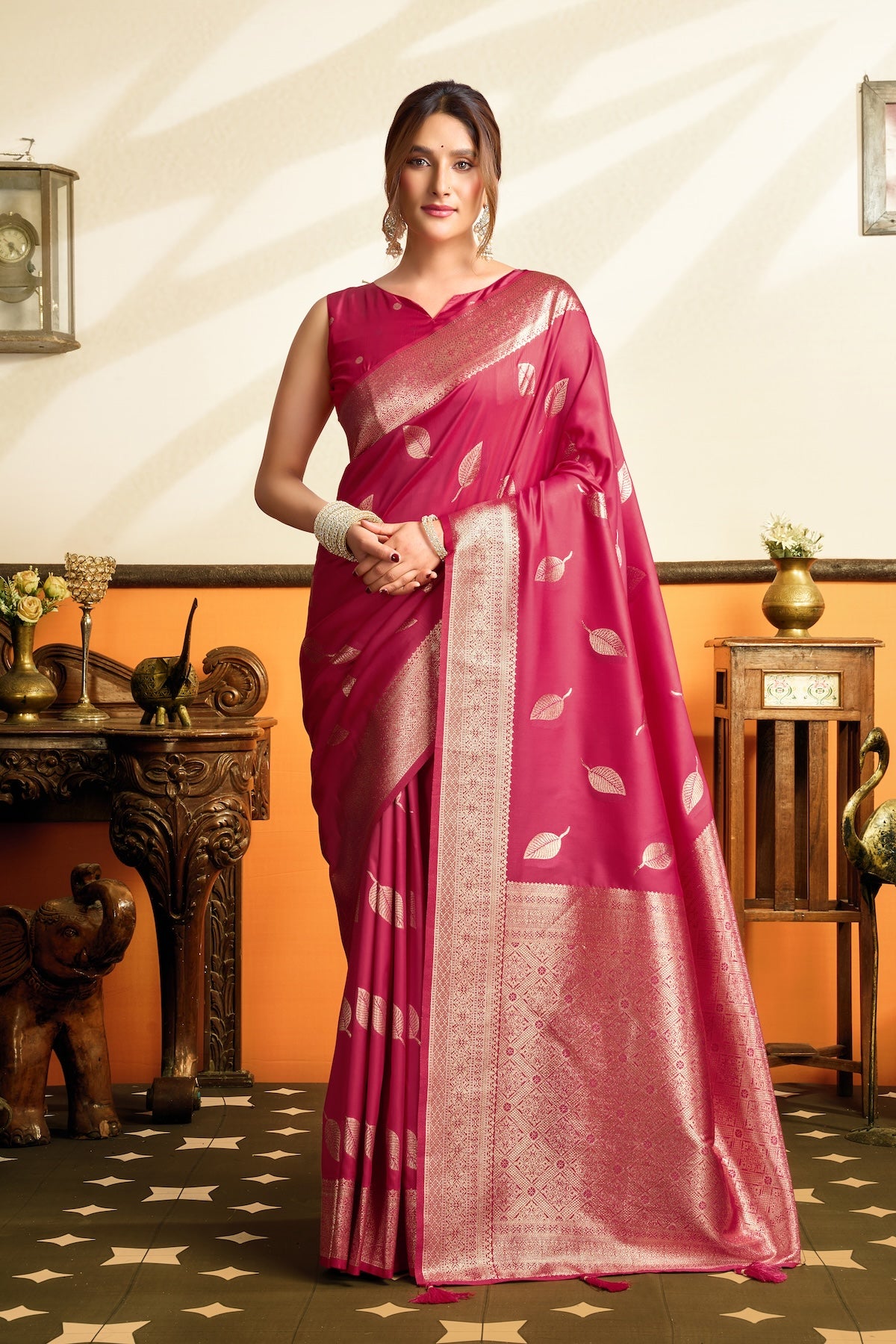 Pink ready-to-wear silk saree with gold zari border and leaf motifs, draped in front