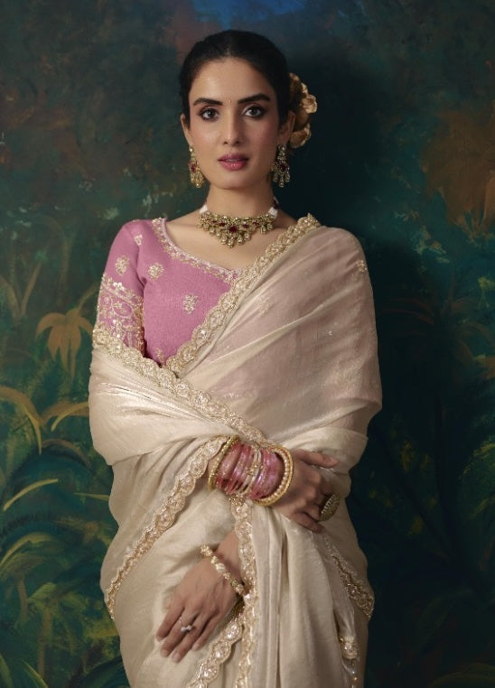 Off-white tissue silk saree with decorative embroidered border, shown draped over a pink blouse