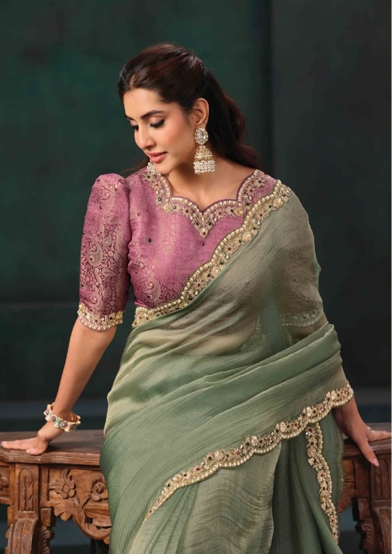 Ready-to-wear green saree draped over a pink embroidered blouse with gold edging