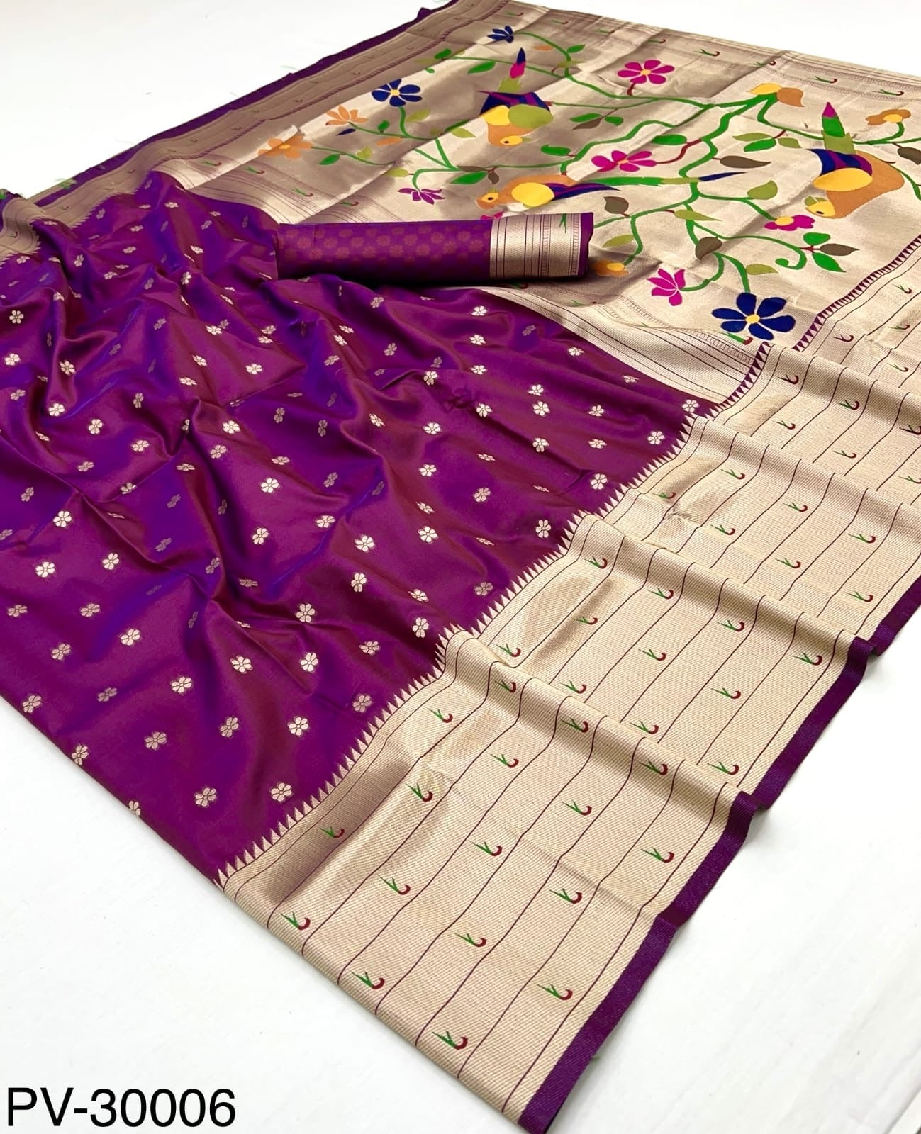 Close-up of magenta silk saree with small gold motifs, beige pleats, colorful pallu