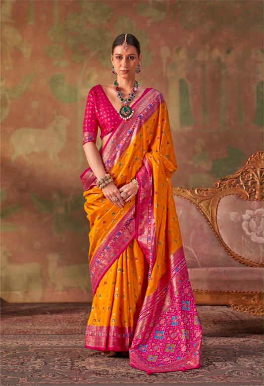 Mustard yellow patola silk sari with pink-magenta border and draped pallu