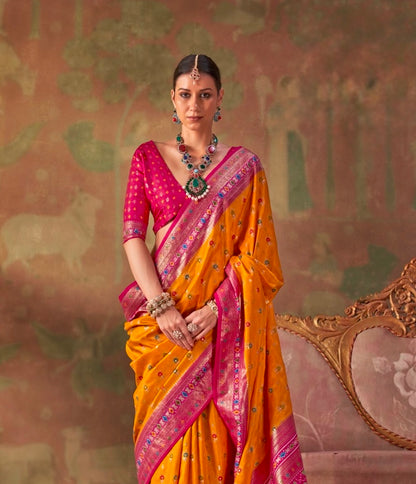 Mustard yellow patola silk sari with pink blouse sleeves and patterned pallu