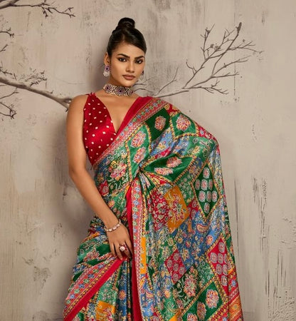 Close view of a model wearing a green and multicolor patterned saree with red trim