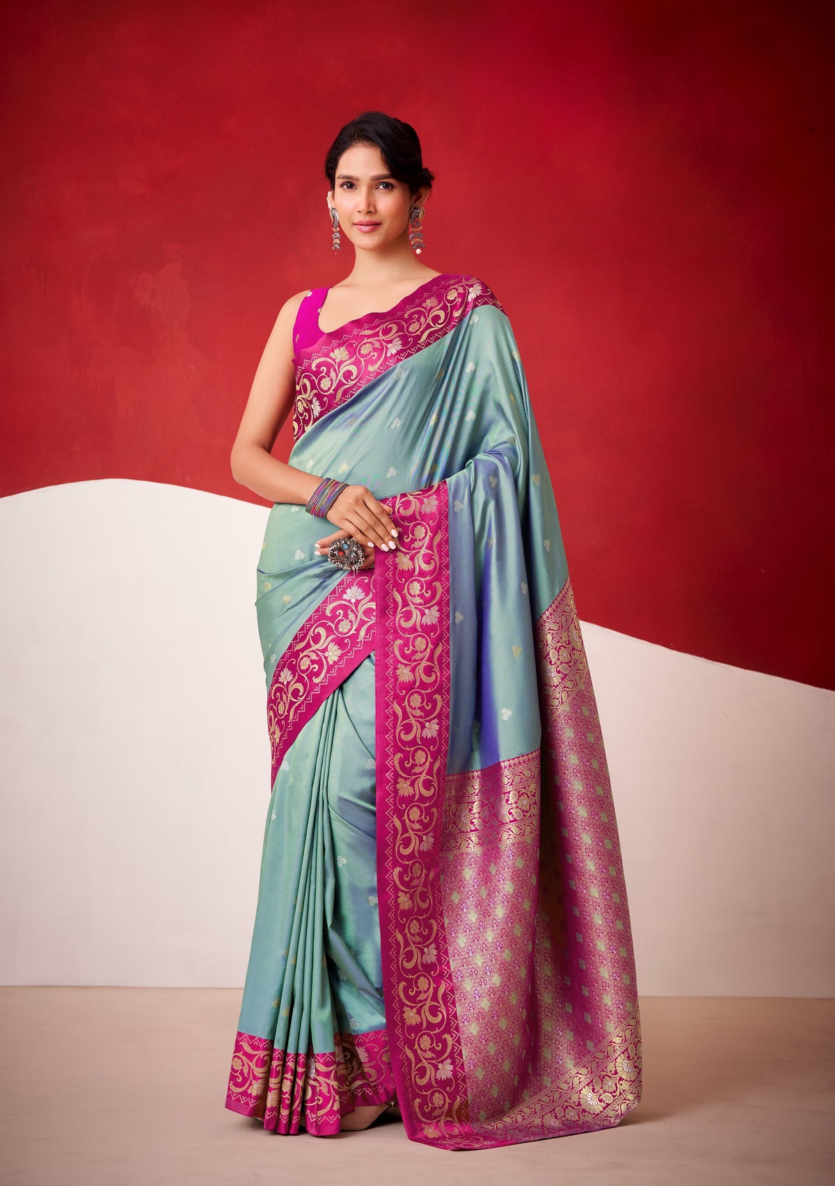 Teal satin silk saree with magenta embroidered border and draped pallu
