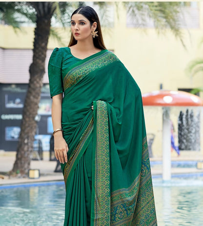 Bottle green crepe silk saree with ornate gold-toned border, draped over shoulder