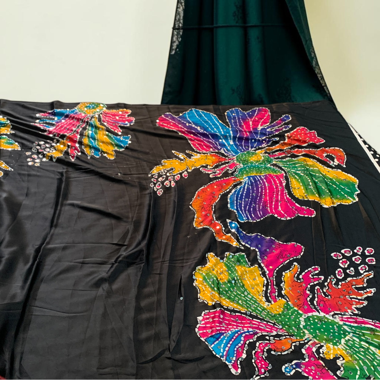 Black saree fabric close-up with vibrant multicolor floral-butterfly embroidery and sequins