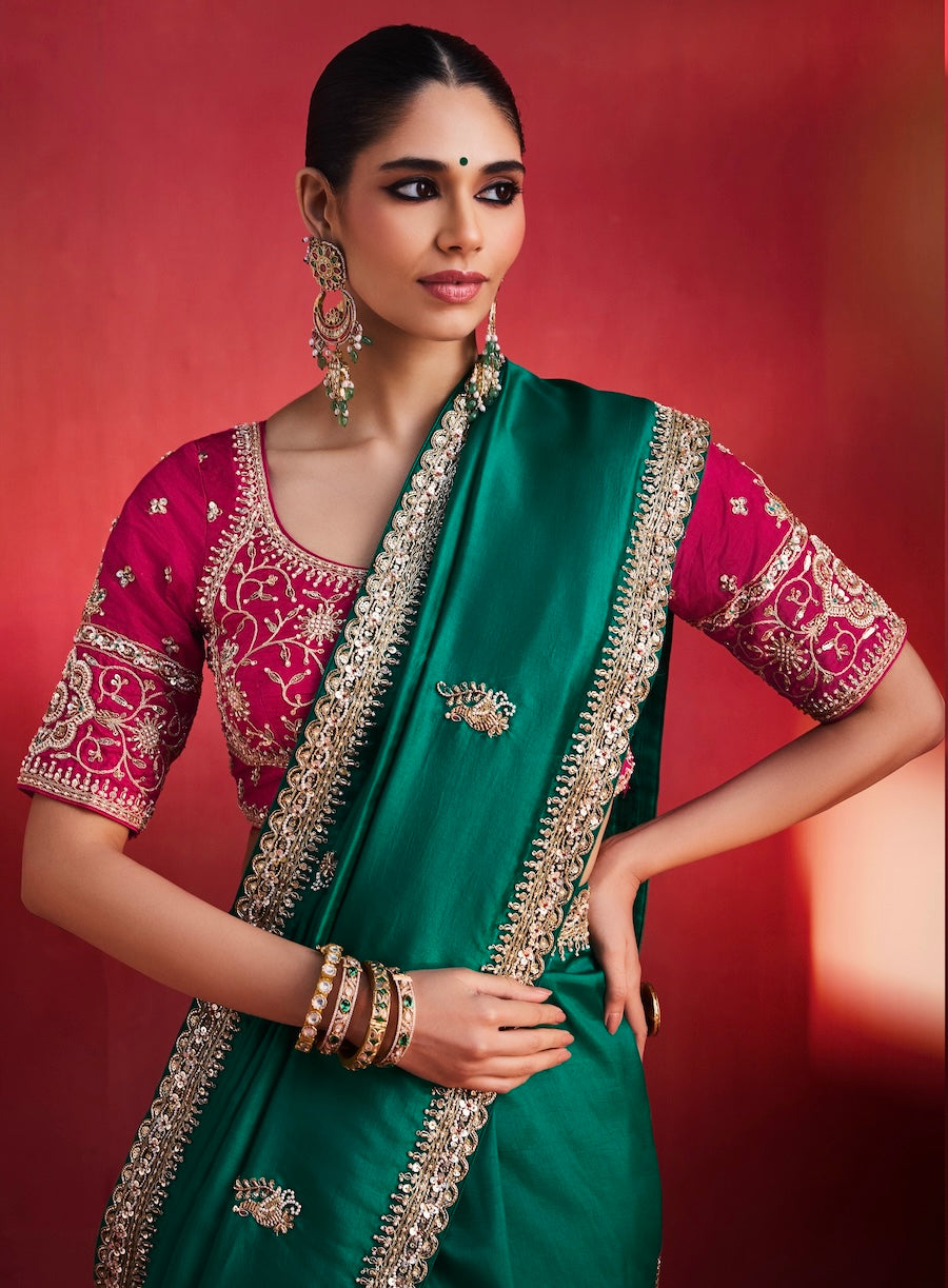 Emerald green saree with gold-embroidered border and maroon patterned blouse, close-up