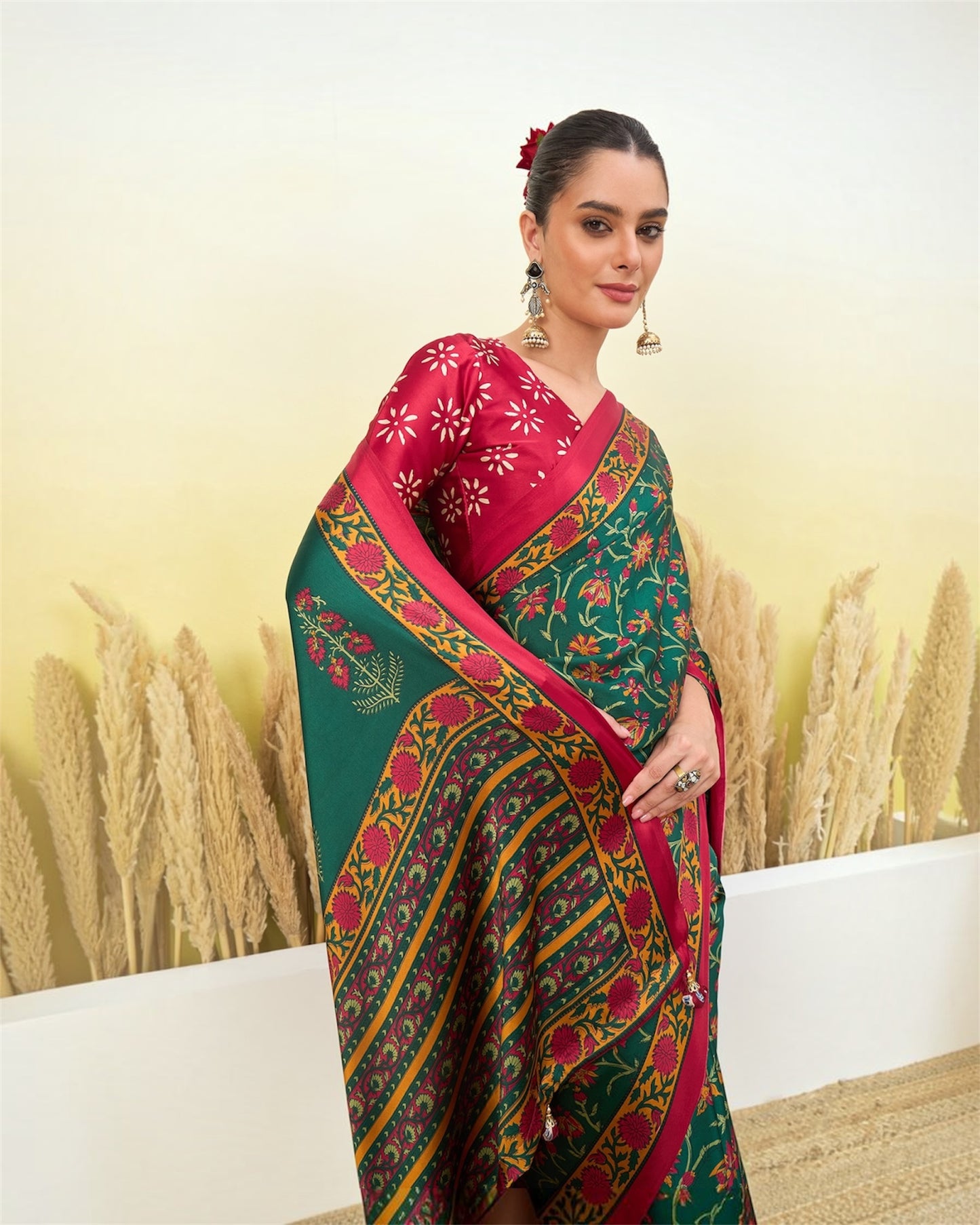 Green printed saree with maroon short-sleeve blouse and ornate gold border