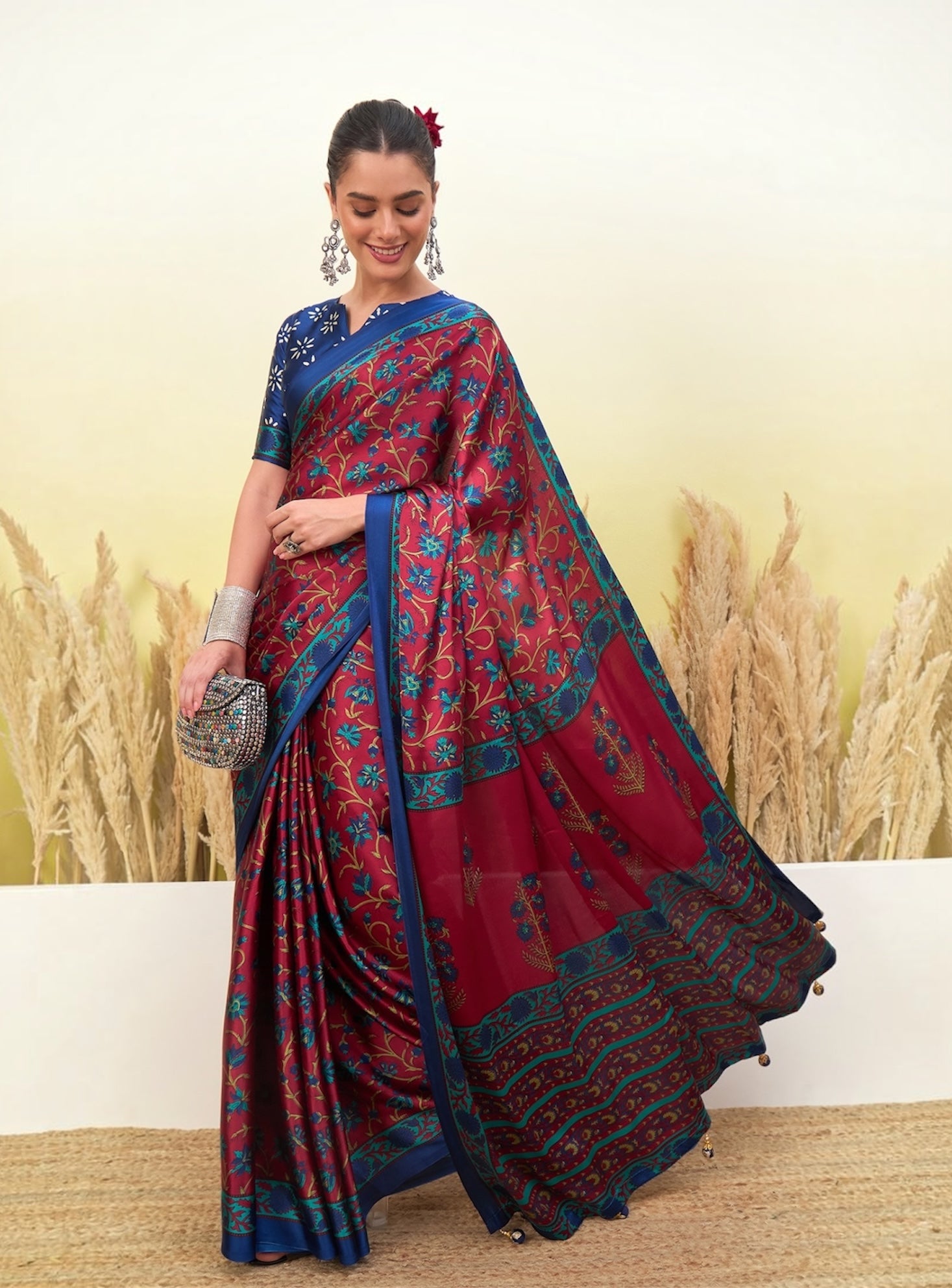 Printed crepe silk saree drape with blue and red floral motifs, border with tassels