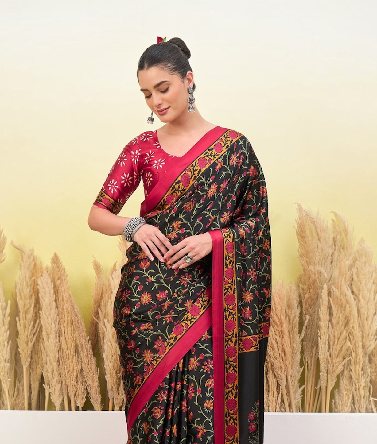 Black crepe silk easy saree with pink floral print, diagonal border stripe, hand pose