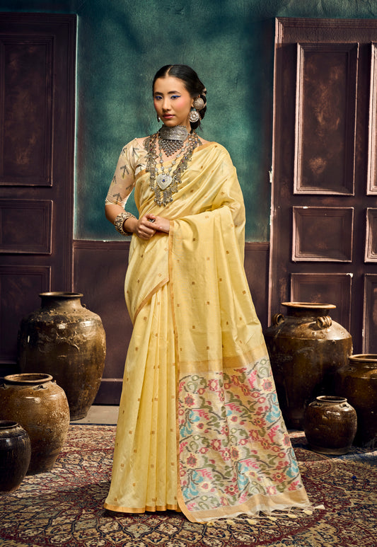 Yellow silk saree with ornate multicolor border, worn with short-sleeve blouse