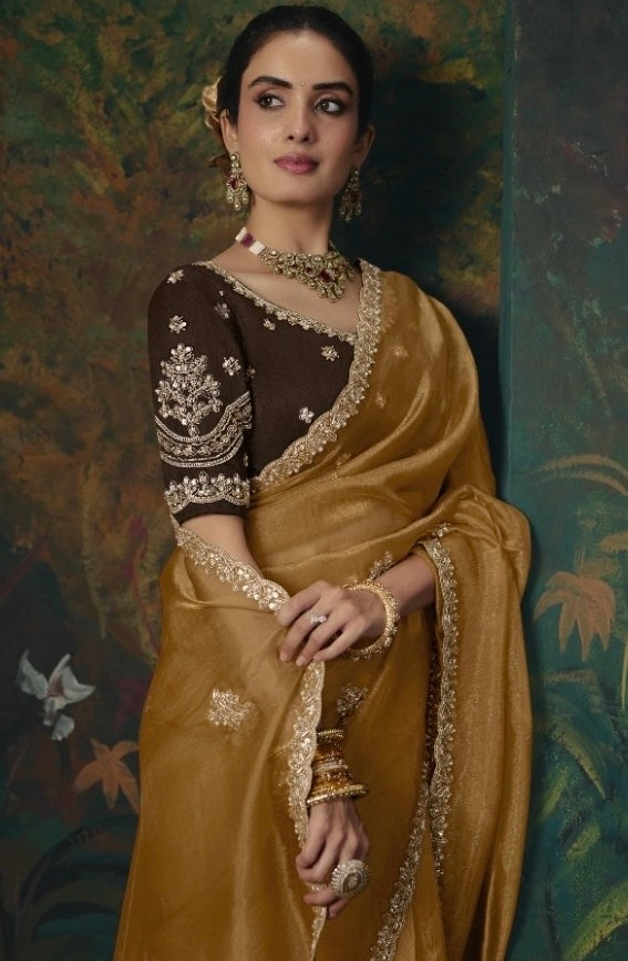 Mustard-gold tissue silk saree with a detailed embroidered border and matching floral motifs