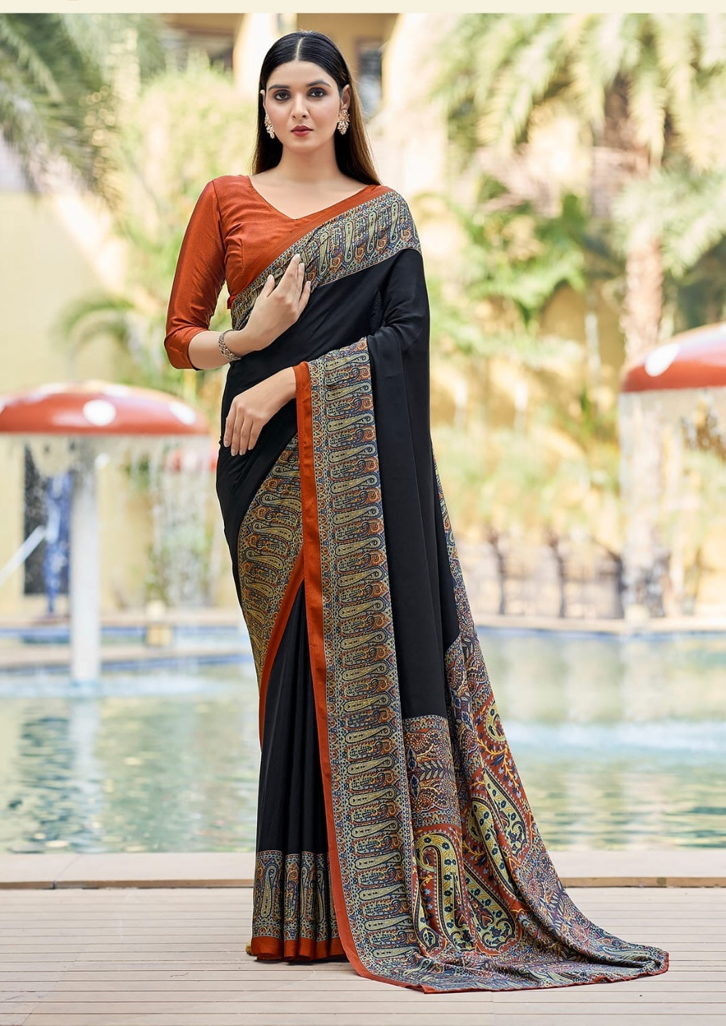 Black crepe silk saree with rust blouse and ornate border, ready-to-wear drape