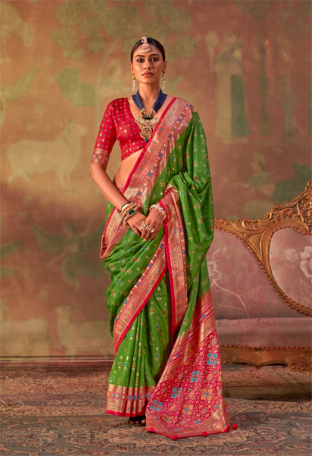 Leaf green patola silk saree with red border and patterned blouse, side drape