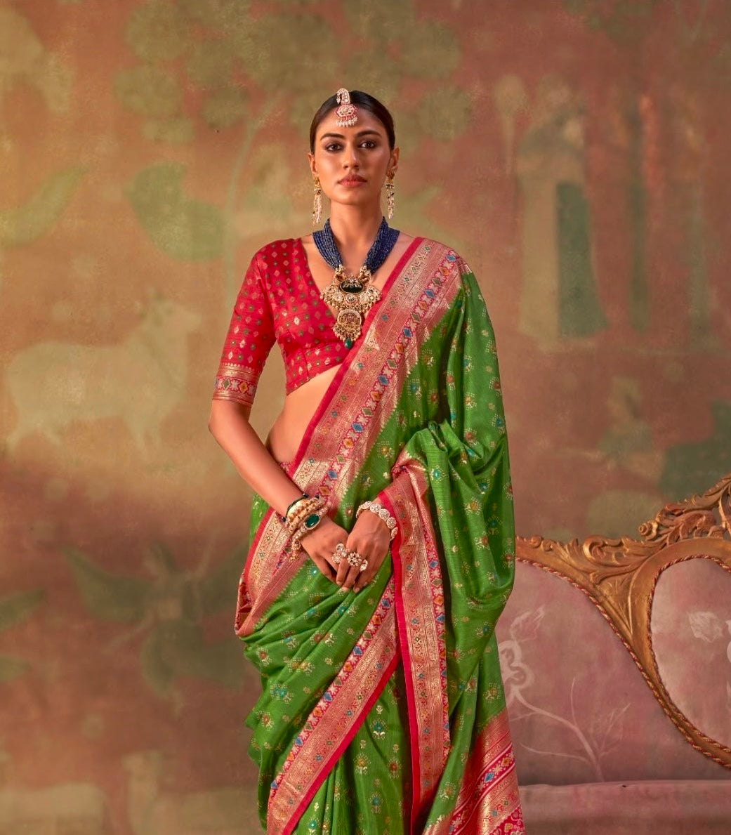 Leaf green patola silk saree with red border and floral motifs, draped over blouse