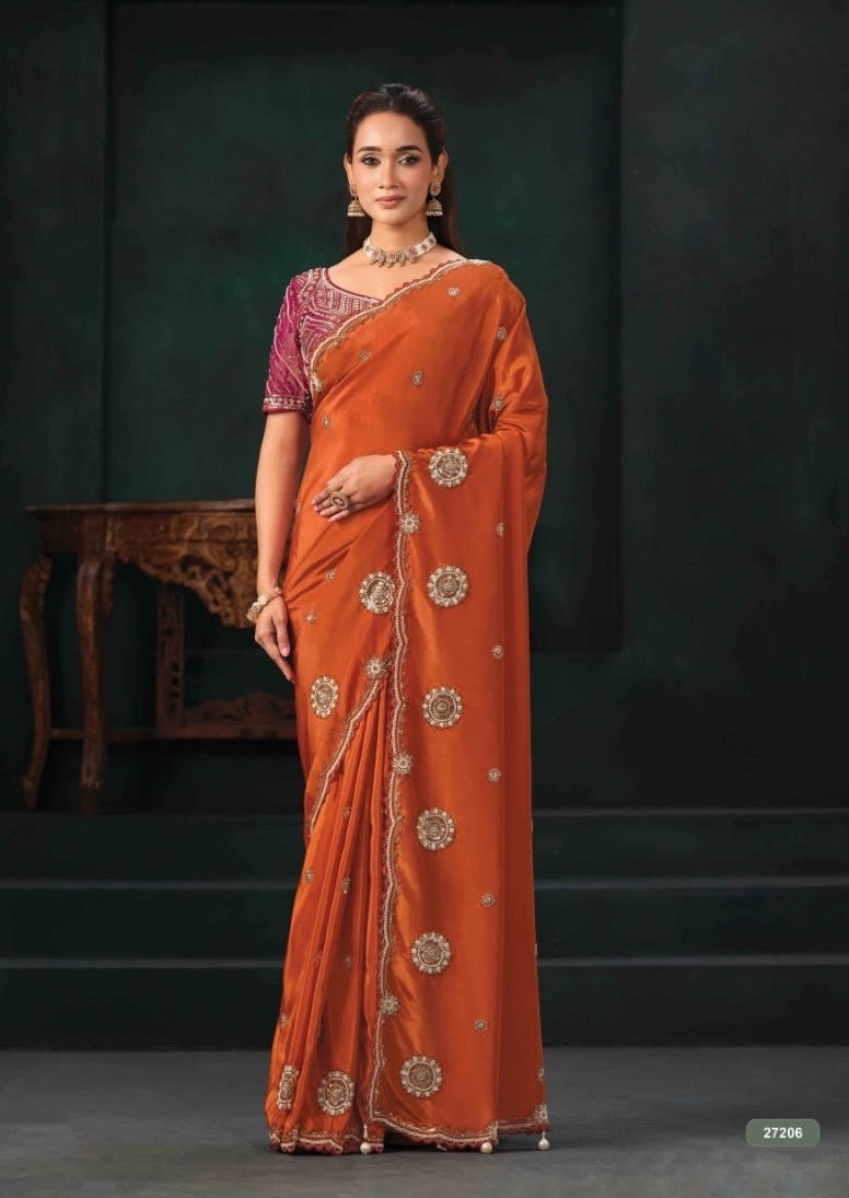 Orange ready-to-wear saree with ornate border and magenta short-sleeve blouse