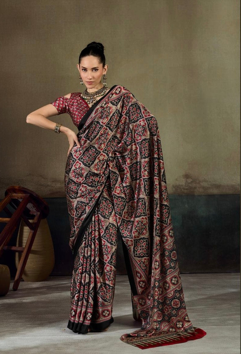 Draped saree with dark base and red geometric motif, wide printed border