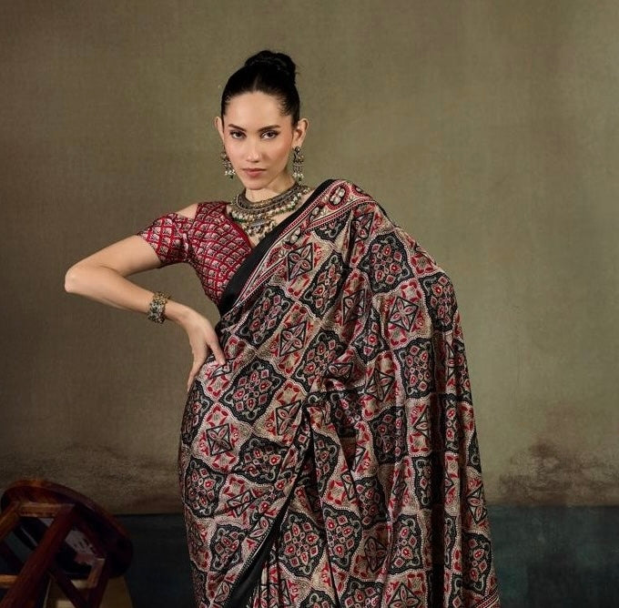 Ready-to-wear saree draped over shoulder, dark base with red geometric pattern