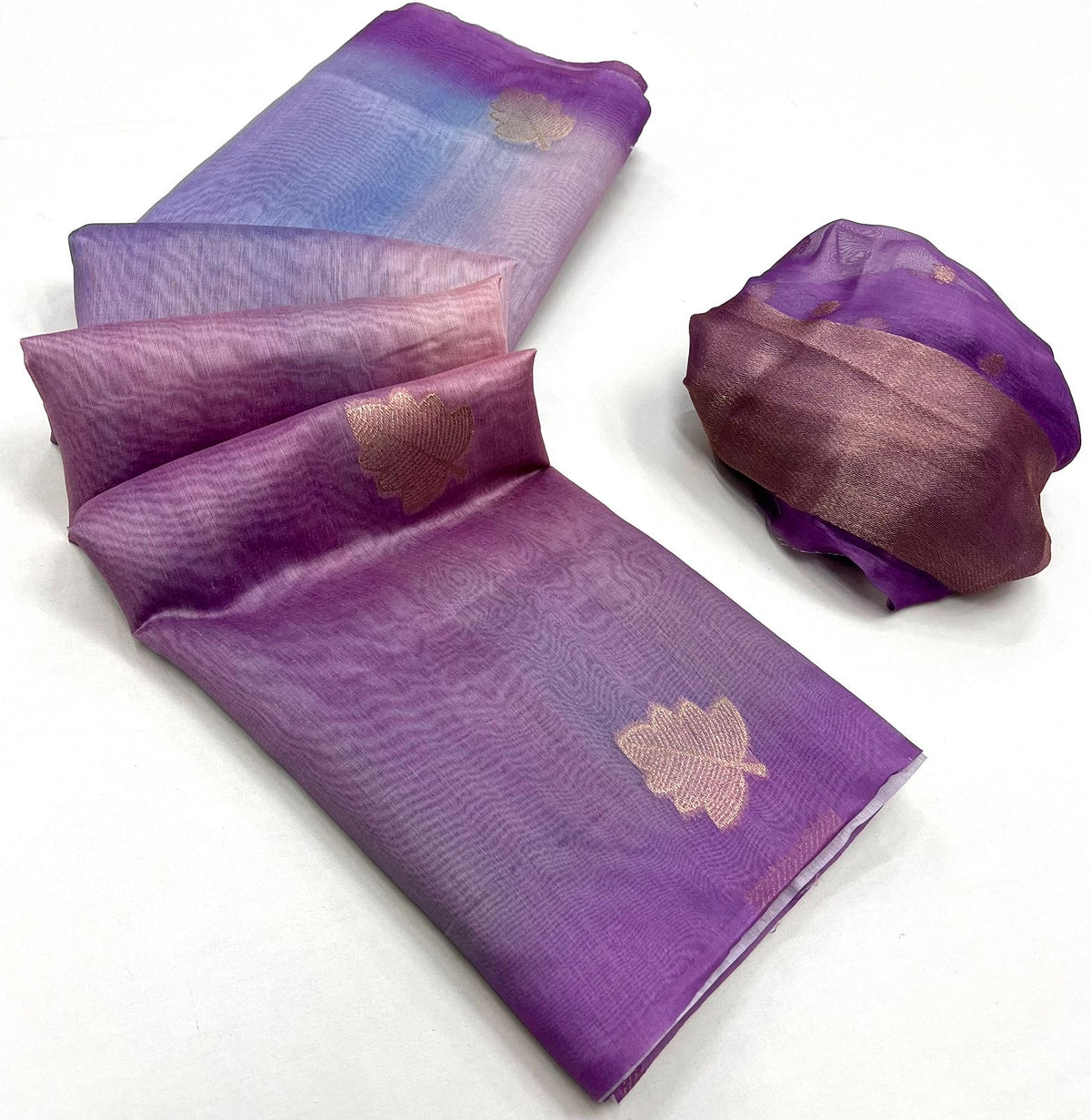 Lavender printed linen saree fabric with gold floral motifs, neatly folded