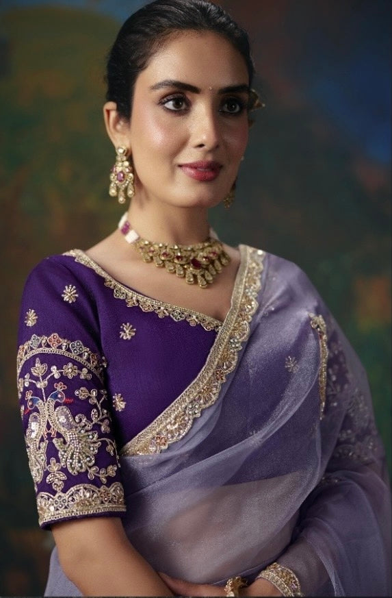 Lavender tissue silk saree with ornate gold border, shown with an embroidered purple blouse