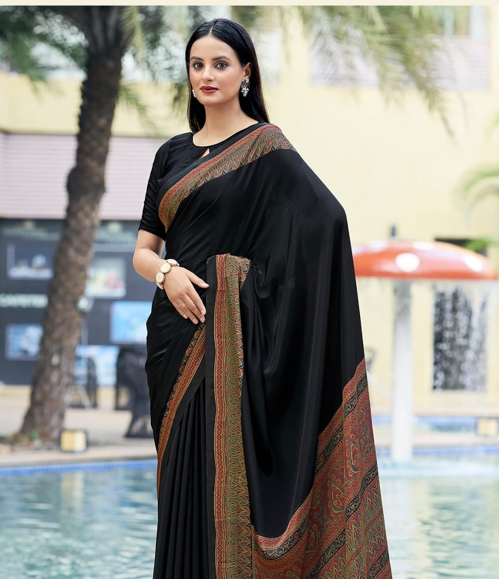 Black crepe silk saree drape with rust-gold border and detailed pallu