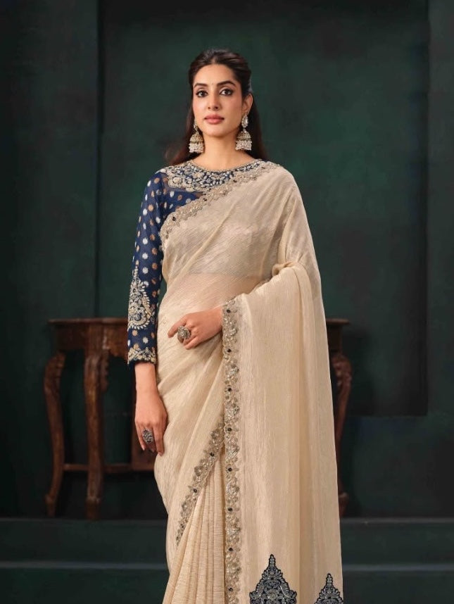 Cream saree draped over a navy embellished blouse, showing the ornate border and sleeve details