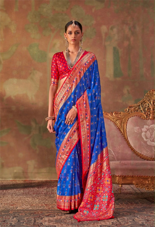 Royal blue silk saree with red and gold border, draped pallu and short-sleeve blouse