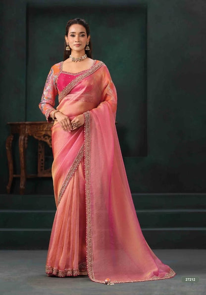 Peach-pink saree with ornate border, draped with a matching long-sleeve embellished blouse.