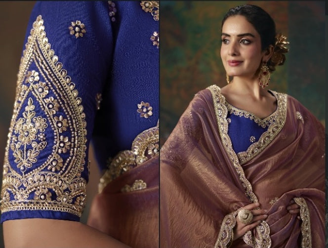 Brown tissue silk saree with ornate gold border, shown with a blue blouse featuring embroidered sleeves.