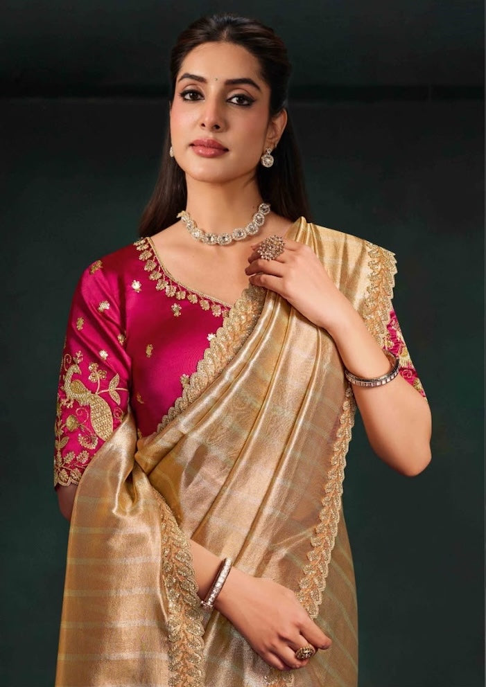 Beige saree with gold trim and magenta embroidered blouse, shown from the waist up