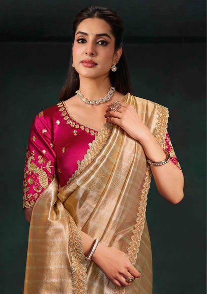 Beige saree with gold trim and magenta embroidered blouse, shown from the waist up