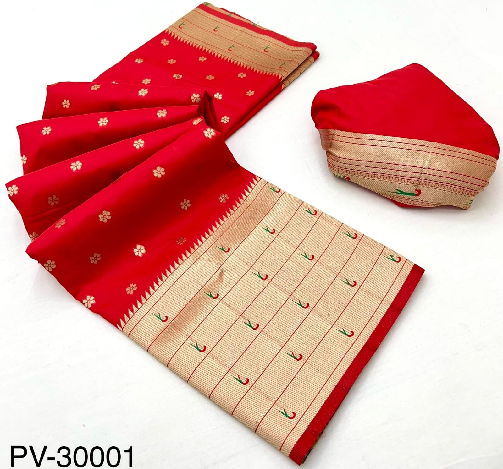 Cherry red saree with beige border and matching folded fabric piece, flat lay