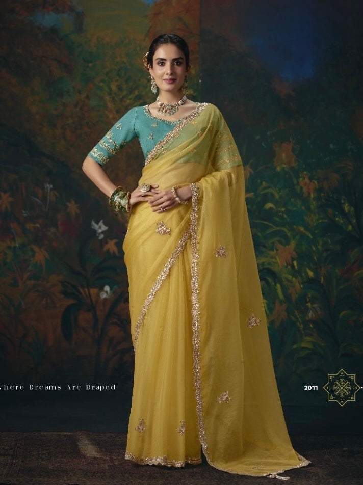 Yellow tissue silk ready-to-wear saree with gold trim and small embroidered motifs, worn with teal blouse